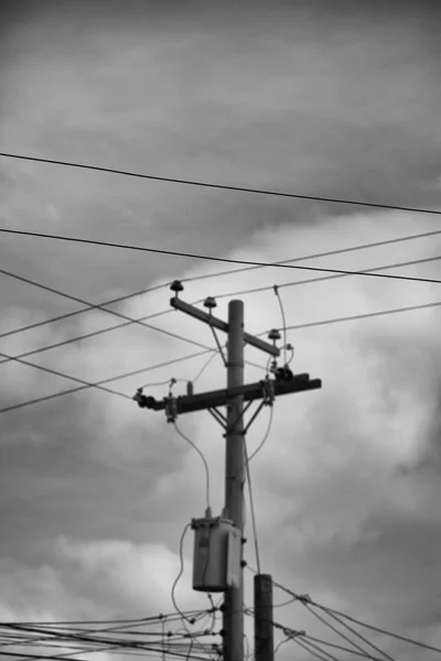 Un poteau électrique avec transformateur et fil le ciel nuageux — Photo