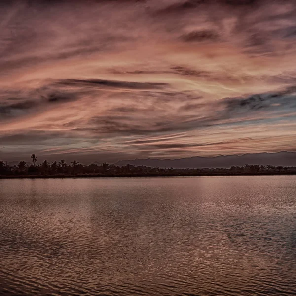 Vista desde el agua del amanecer llena de colores — Foto de Stock