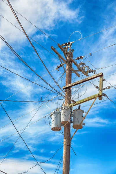 Trafo ve tel bulutlu gökyüzü ile bir elektrik direği — Stok fotoğraf