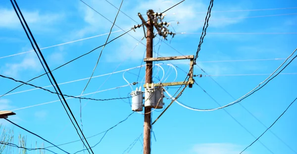 Um poste elétrico com transformador e fio o céu nublado — Fotografia de Stock