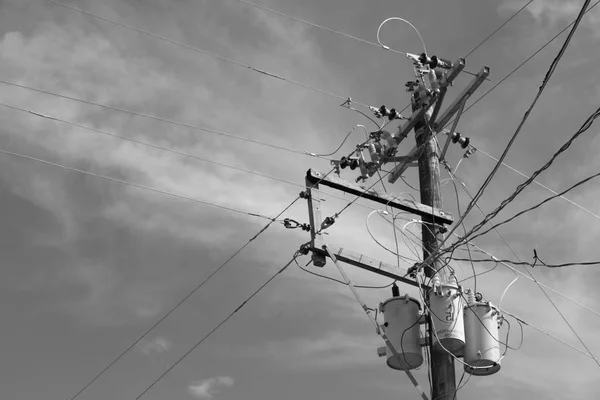 Słup elektryczny z transformatorem i drutu pochmurnego nieba — Zdjęcie stockowe