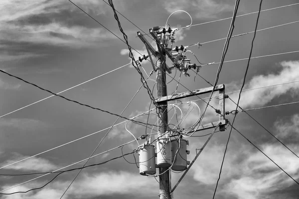 Um poste elétrico com transformador e fio o céu nublado — Fotografia de Stock