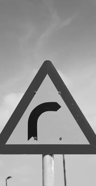 Estrada sinalizar atenção da curva no céu — Fotografia de Stock