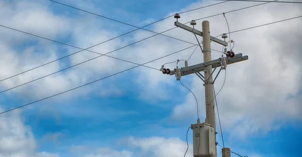 Trafo ve tel bulutlu gökyüzü ile bir elektrik direği — Stok fotoğraf