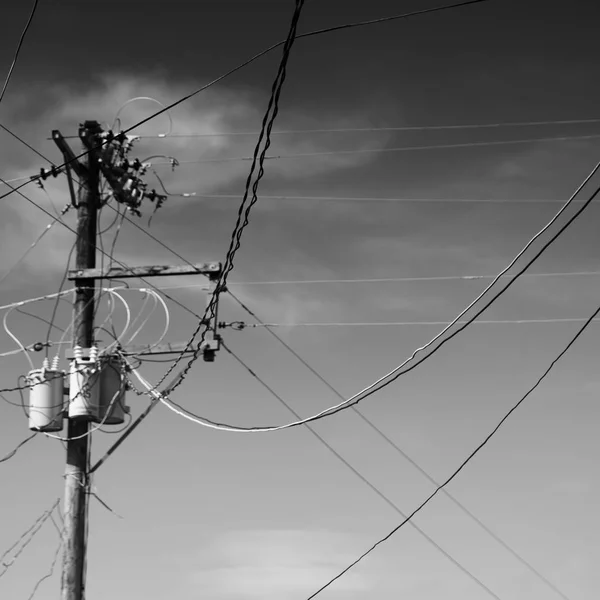 Um poste elétrico com transformador e fio o céu nublado — Fotografia de Stock