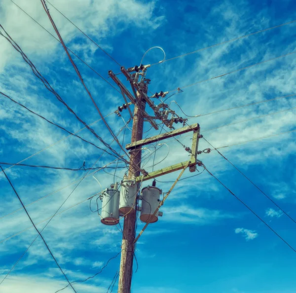 Un poste eléctrico con transformador y alambre el cielo nublado —  Fotos de Stock