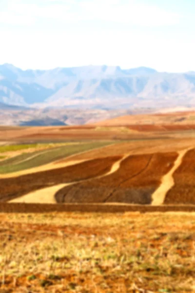 Pueblo de la calle cerca de la montaña y campo de coultivation — Foto de Stock