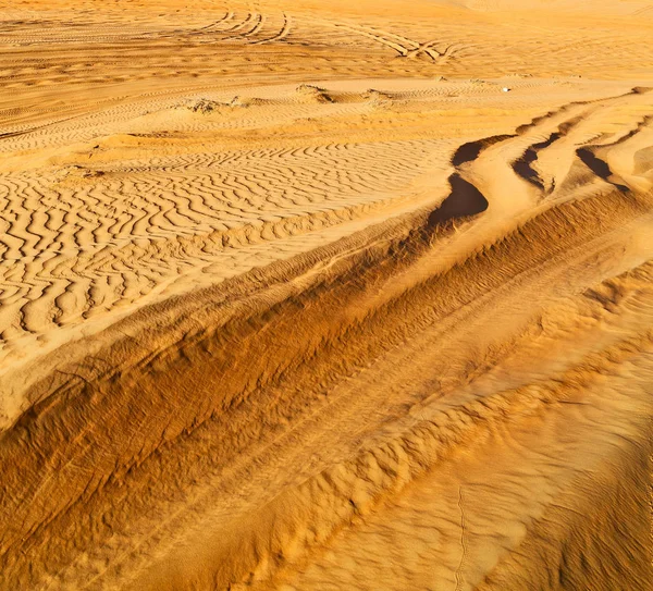 Пустынная трасса некоторых машин в песке и направление движения — стоковое фото