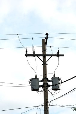 trafo ve tel bulutlu gökyüzü ile bir elektrik direği