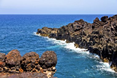 Beyaz kıyısında lanzarote İspanya plaj taş su ve yaz kahverengi kaya 