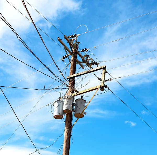 Um poste elétrico com transformador e fio o céu nublado — Fotografia de Stock