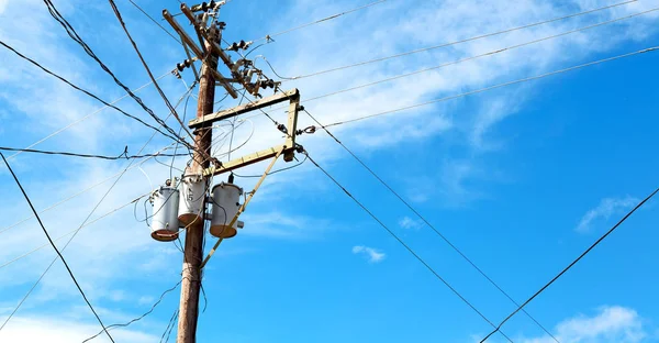 A electric pole with transformer and wire  the cloudy sky — Stock Photo, Image