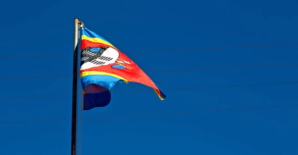 Im Swasiland Flagge und Himmel schwenkend — Stockfoto