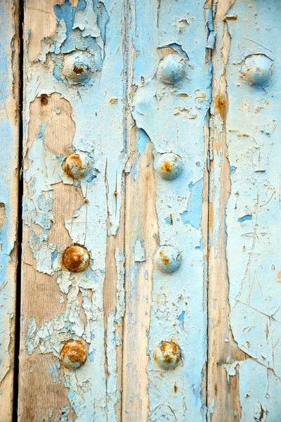 Dirty stripped paint the blue wood door   rusty nail — Stock Photo, Image