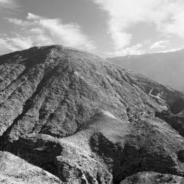  Doygun ve kanyon. Karanlık bulutlu gökyüzü. Umman 'daki eski dağ. 