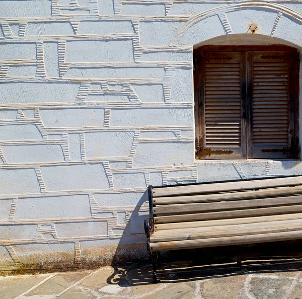 En la isla griega de paros viejo banco cerca de un ladrillo antiguo wal —  Fotos de Stock