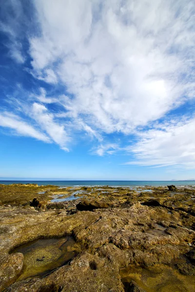 Luce spiaggia acqua schiuma roccia spagna paesaggio pietra cielo nube — Foto Stock