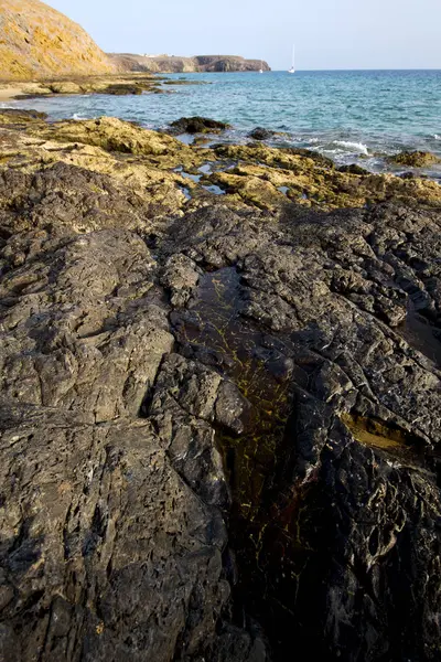 Spanien ljus stranden båt yacht i Lanzarotes kust rock wate — Stockfoto