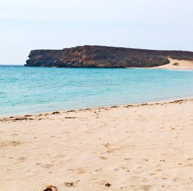 Umman Arapça deniz kumlu plaj gökyüzü ve dağ yakınlarındaki tepe