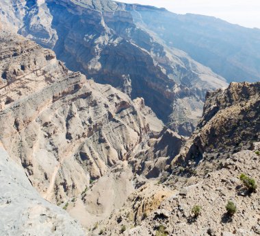  Doygun ve kanyon. Karanlık bulutlu gökyüzü. Umman 'daki eski dağ. 