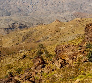  Doygun ve kanyon. Karanlık bulutlu gökyüzü. Umman 'daki eski dağ. 