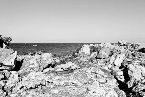 В прибрежных водах Черного моря скала и пляж отдыхают под небом — стоковое фото