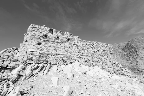 En Oman la vieja casa abandonada del arco del pueblo y cielo nublado —  Fotos de Stock