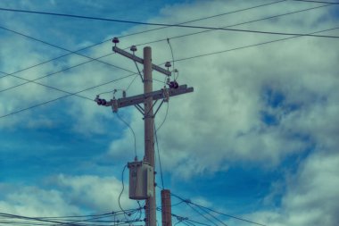 trafo ve tel bulutlu gökyüzü ile bir elektrik direği