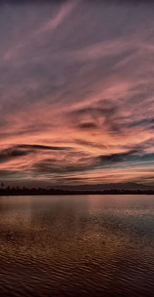 Vista desde el agua del amanecer llena de colores — Foto de Stock