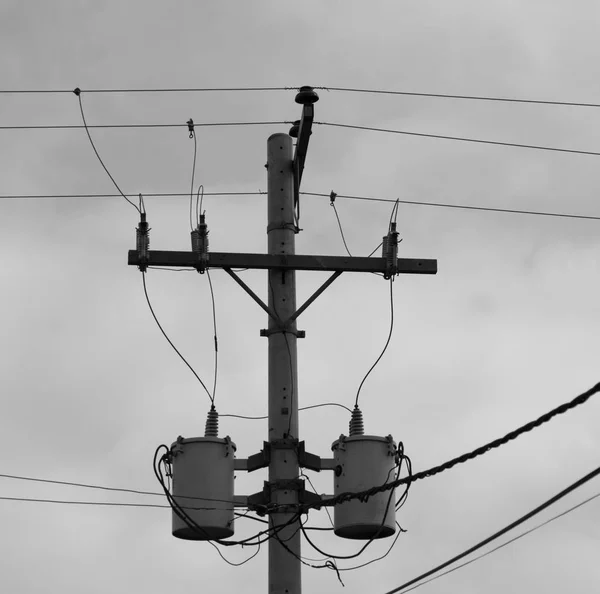 Un palo elettrico con trasformatore e filo il cielo nuvoloso — Foto Stock