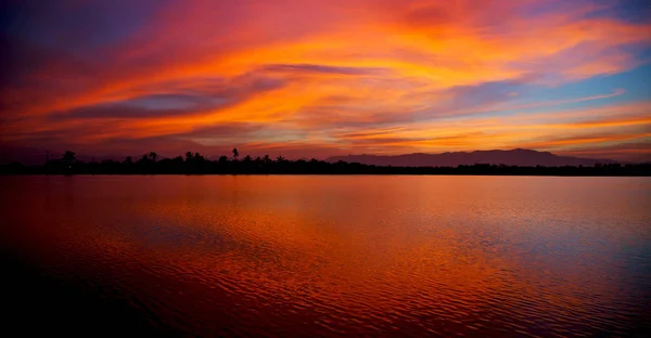 Vista desde el agua del amanecer llena de colores — Foto de Stock