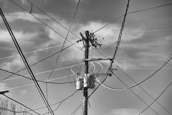 A electric pole with transformer and wire  the cloudy sky — Stock Photo, Image