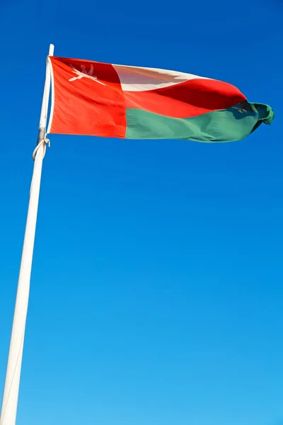 Em oman acenando bandeira e o céu nublado — Fotografia de Stock