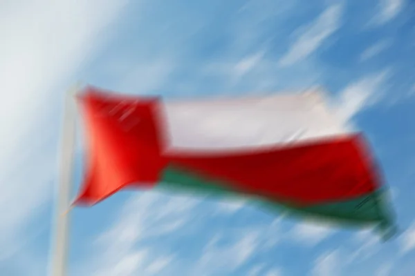 Dans le drapeau oman agitant et le flou — Photo