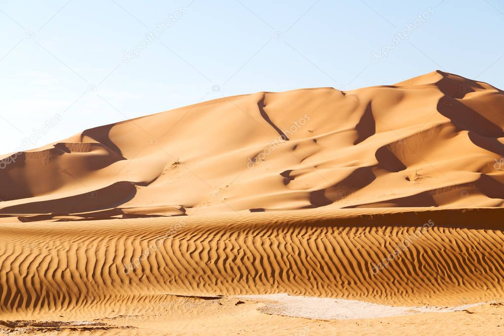 tranquil dunes under clear blue sky in oman, rub al khali 