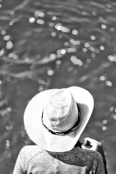 Unknown woman with hat looking at the ocean — Stock Photo, Image