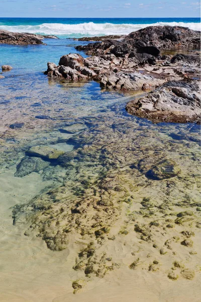 A praia perto das rochas na onda do oceano — Fotografia de Stock