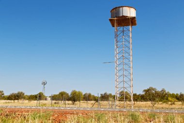 Avustralya outback asfalt hattı ve su tankı ile uzak kavramı