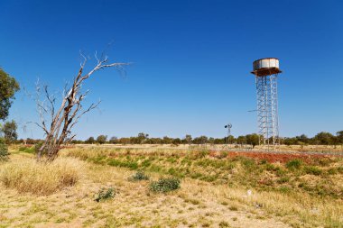 Avustralya outback asfalt hattı ve su tankı ile uzak kavramı