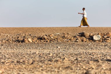 Etiyopya, Danakil-Ocak 2018--rock çölde yürüyen kimliği belirsiz adam yaklaşık