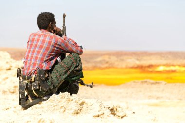  arazi danakil Etiyopya Afrika'da siyah bir asker ve silahını yatılı arıyorsunuz