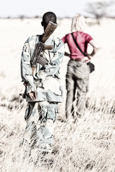Черный солдат с пистолетом, смотрящим на пансион — стоковое фото