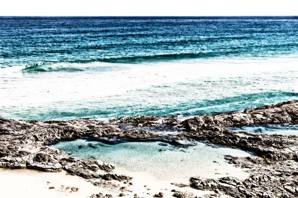 La playa cerca de las rocas en la ola del océano — Foto de Stock