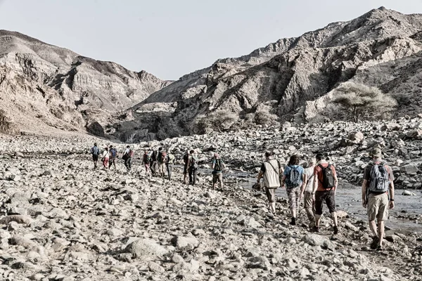 in   ethiopia africa   lots of people  hiking in the  canyon empty river