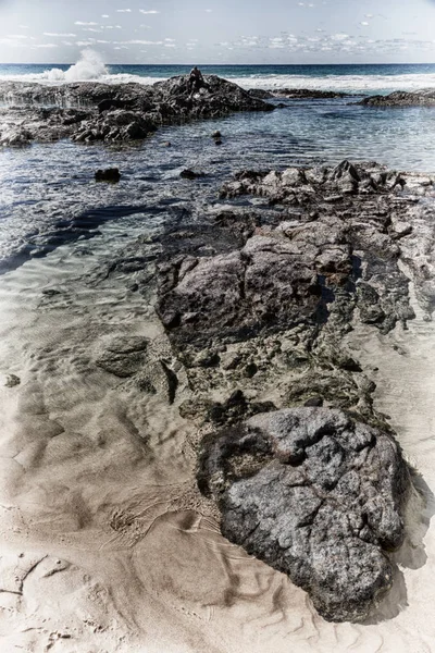 Der Strand in der Nähe der Felsen in der Welle des Ozeans — Stockfoto