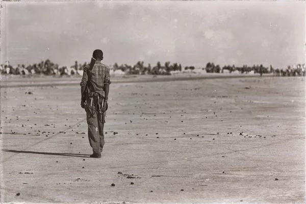 En svart soldat och bössan ser gränsen — Stockfoto
