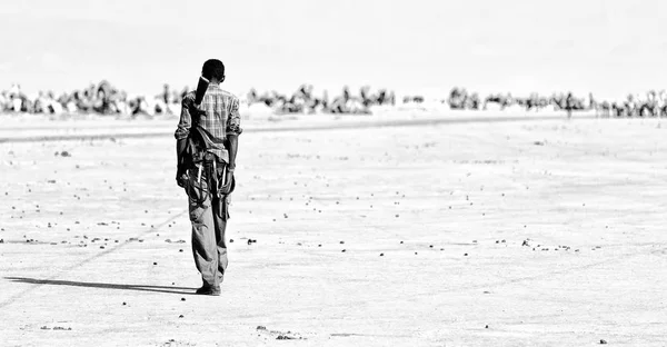 africa  in the land of danakil ethiopia a black soldier and his gun looking the boarder