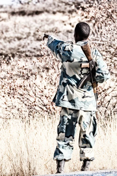 Un soldado negro y su arma mirando la frontera —  Fotos de Stock