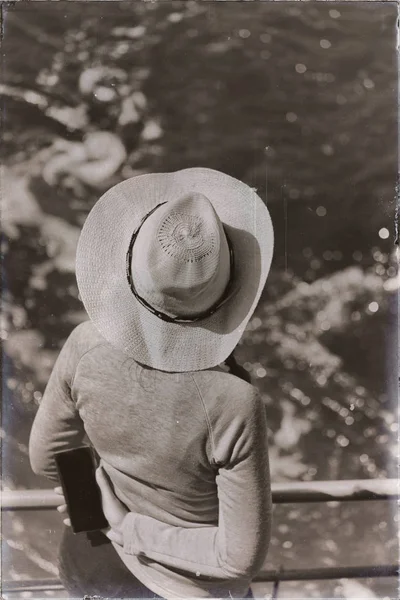 未知的女人带着帽子看着大海 — 图库照片