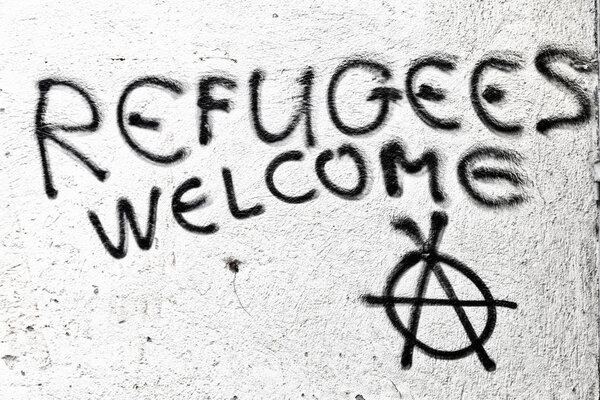 the spray paint in the wall with refugees welcome